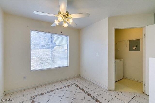 empty room with washer and clothes dryer, light tile patterned floors, electric panel, and ceiling fan