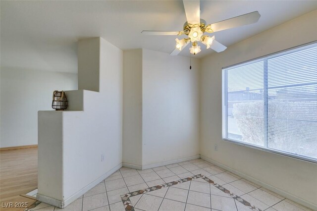 tiled spare room featuring ceiling fan