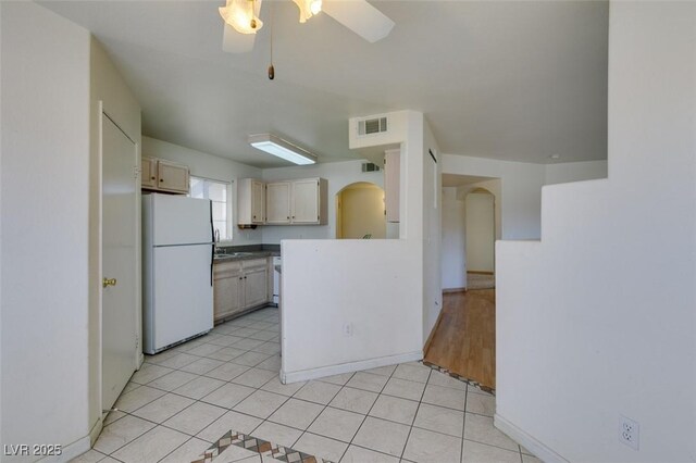 kitchen featuring ceiling fan, sink, light tile patterned floors, and white refrigerator