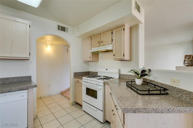 kitchen with light brown cabinets, white appliances, and light tile patterned floors