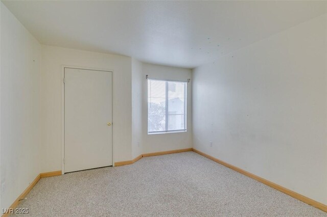 spare room featuring light carpet