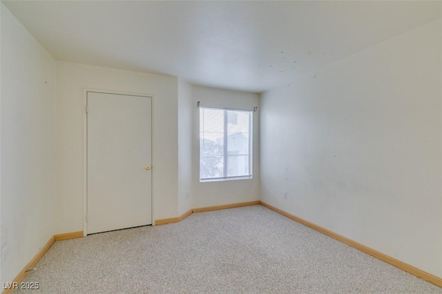 carpeted empty room with baseboards