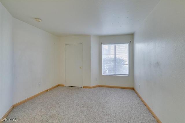 carpeted empty room with baseboards