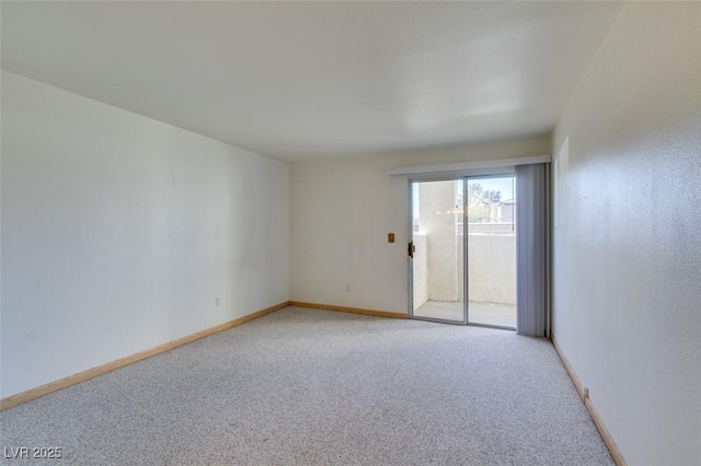 unfurnished room with light colored carpet and baseboards