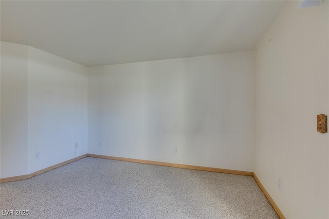 unfurnished room with baseboards and light colored carpet