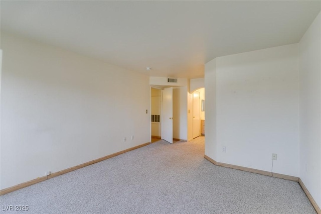 empty room featuring light colored carpet, visible vents, and baseboards