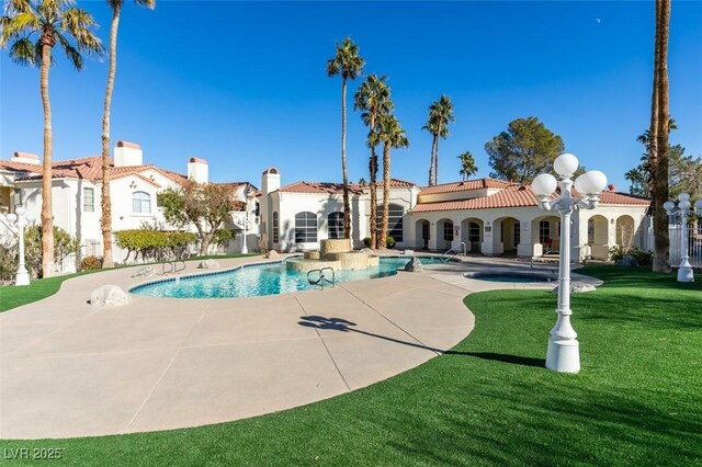 view of swimming pool featuring a yard and a patio