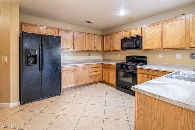 kitchen featuring light tile patterned floors, sink, and black appliances