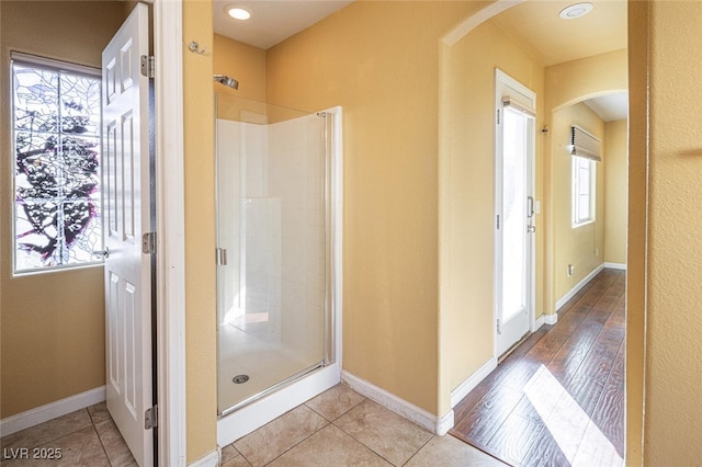 bathroom featuring tile patterned flooring, an enclosed shower, and a healthy amount of sunlight