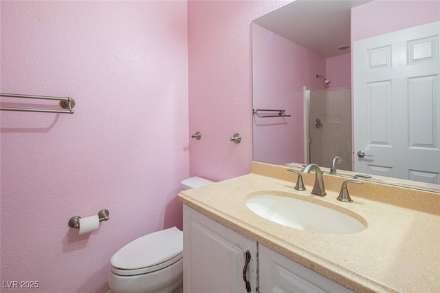 bathroom featuring vanity, toilet, and walk in shower