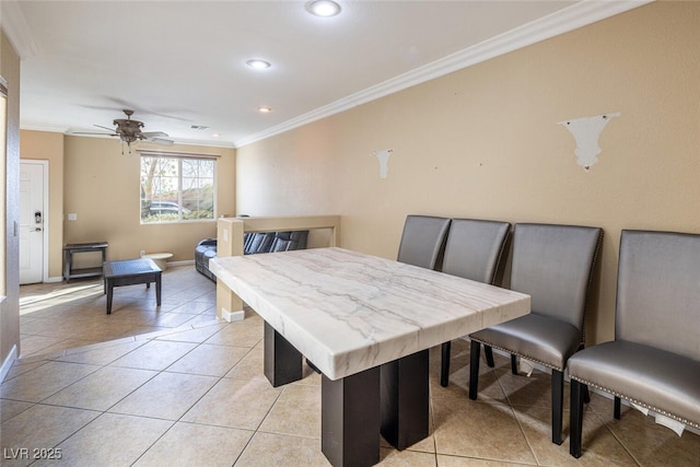 tiled dining space with ceiling fan and crown molding