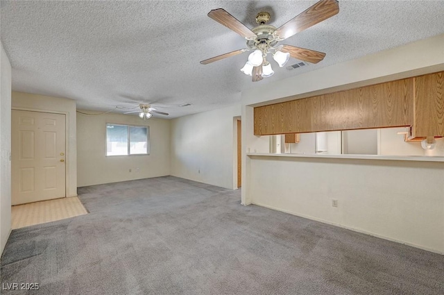 interior space with light carpet, a textured ceiling, and ceiling fan