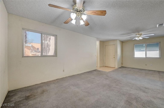 unfurnished room featuring a textured ceiling, light colored carpet, and ceiling fan