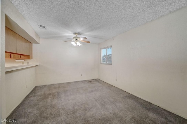 unfurnished room featuring light carpet, ceiling fan, and a textured ceiling