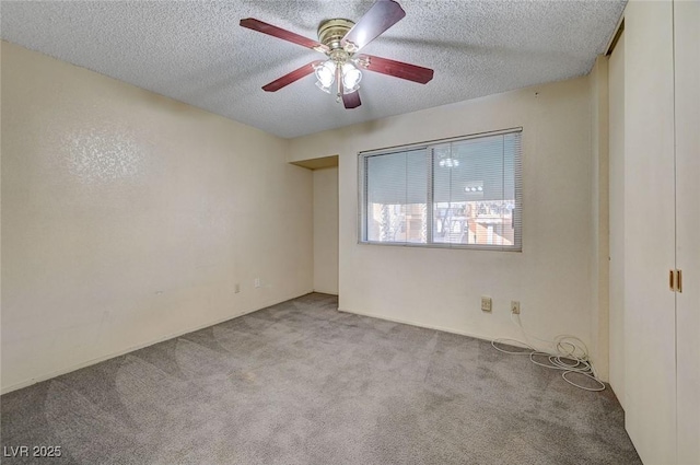 carpeted spare room with ceiling fan and a textured ceiling