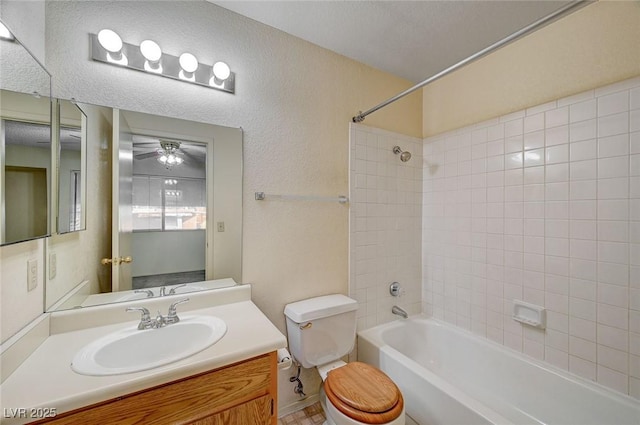 full bathroom featuring vanity, toilet, tiled shower / bath, and ceiling fan