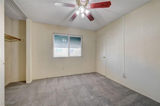 carpeted empty room featuring ceiling fan and a textured ceiling