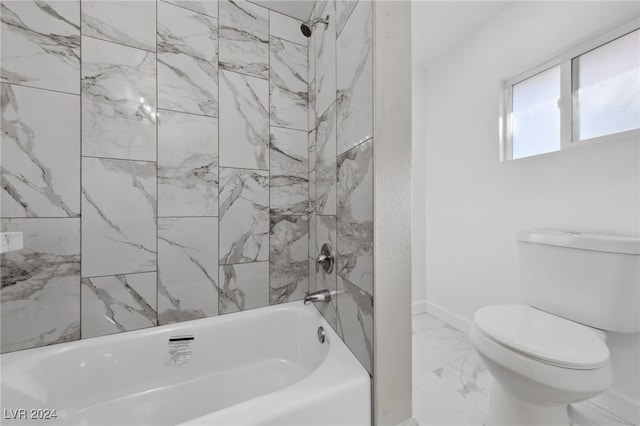 bathroom featuring toilet and tiled shower / bath