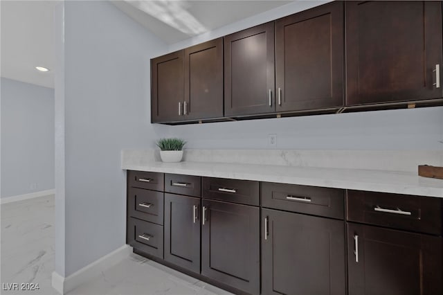 kitchen with dark brown cabinetry and vaulted ceiling