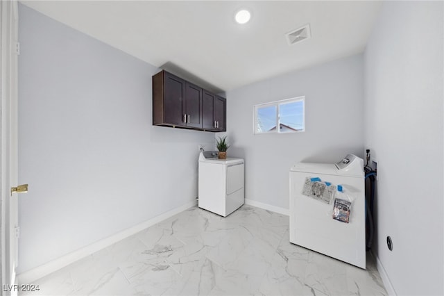 washroom with washing machine and clothes dryer and cabinets