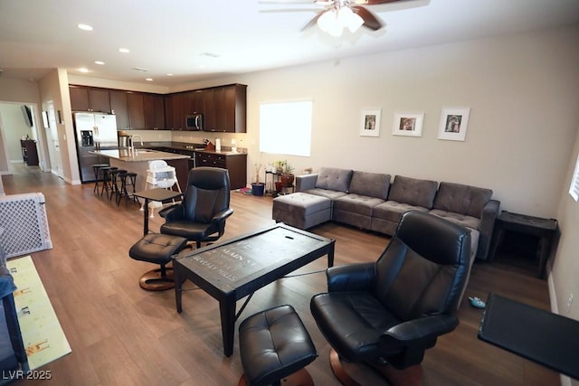 living room with ceiling fan, sink, and light hardwood / wood-style flooring