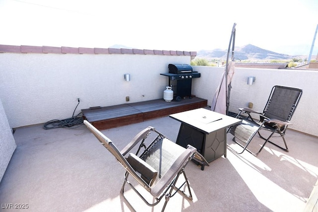 view of patio with a mountain view, area for grilling, and a balcony