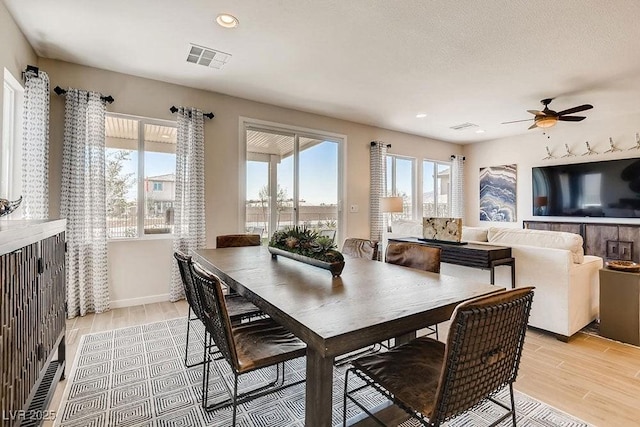 dining room featuring plenty of natural light, light hardwood / wood-style floors, a textured ceiling, and ceiling fan