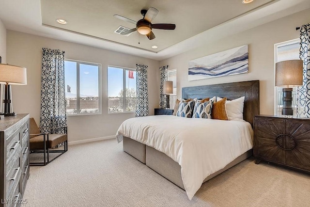 bedroom with a tray ceiling, ceiling fan, and light colored carpet