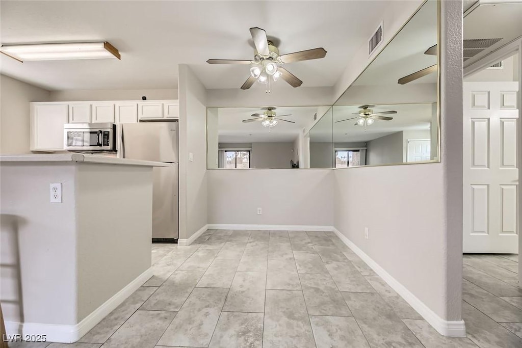 kitchen featuring kitchen peninsula, stainless steel appliances, and white cabinetry