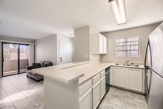 kitchen featuring kitchen peninsula, sink, white cabinets, black dishwasher, and stainless steel refrigerator