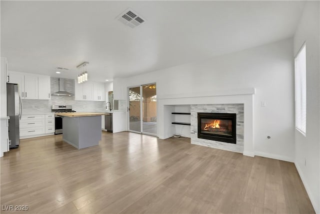 unfurnished living room with a healthy amount of sunlight, light wood-type flooring, and a fireplace