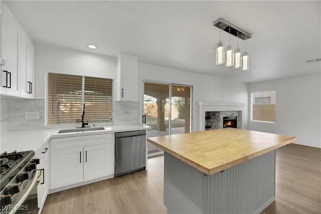 kitchen with backsplash, sink, white cabinets, and stainless steel appliances