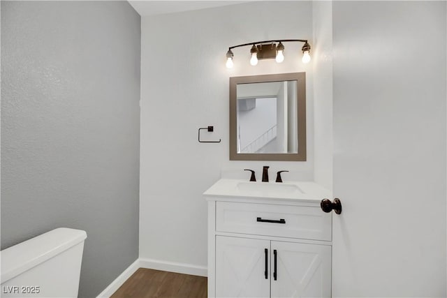 bathroom with vanity, hardwood / wood-style flooring, and toilet