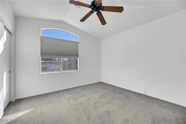 carpeted spare room with ceiling fan and lofted ceiling