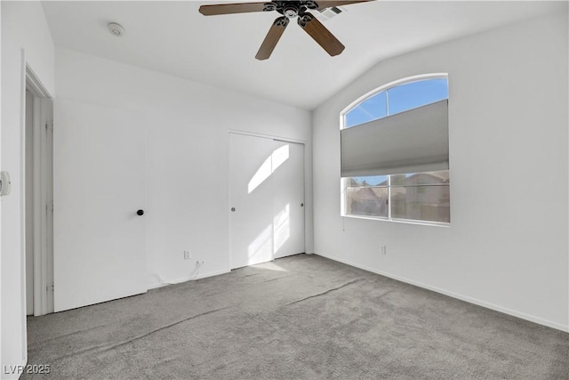 unfurnished living room featuring light colored carpet, vaulted ceiling, and ceiling fan