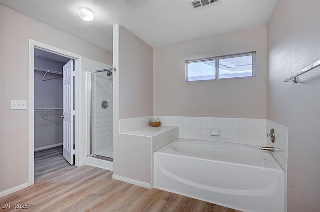 bathroom featuring hardwood / wood-style floors and separate shower and tub