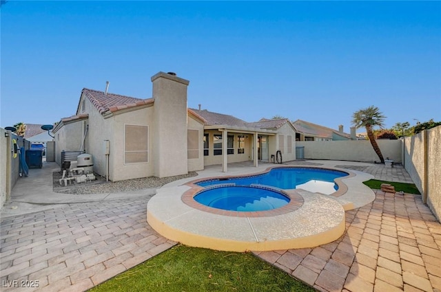 view of swimming pool with an in ground hot tub and a patio