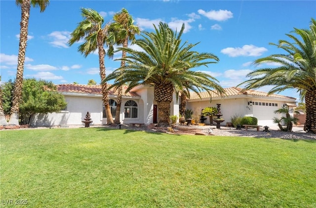 mediterranean / spanish home with a front lawn and a garage