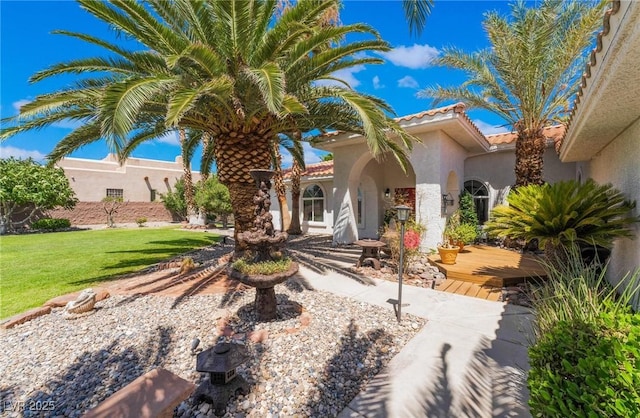 mediterranean / spanish house with a front lawn and a wooden deck