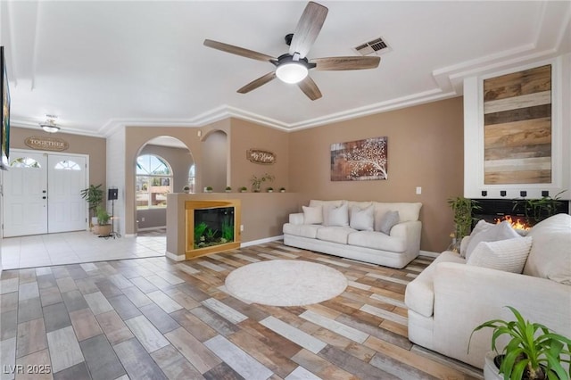 living room with ceiling fan and ornamental molding