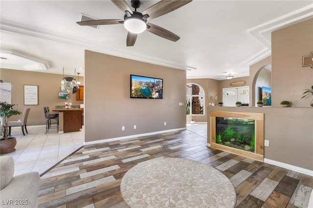 living room with ceiling fan and ornamental molding