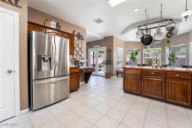 kitchen featuring stainless steel fridge with ice dispenser, light tile patterned floors, and french doors