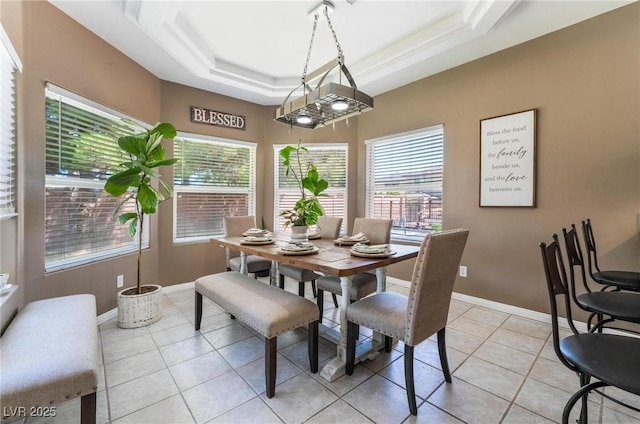 tiled dining area featuring a raised ceiling