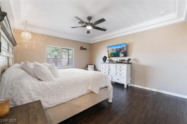 bedroom featuring ceiling fan with notable chandelier, a raised ceiling, and dark wood-type flooring