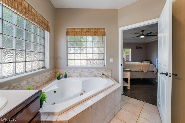 bathroom with a relaxing tiled tub, tile patterned floors, ceiling fan, and a healthy amount of sunlight