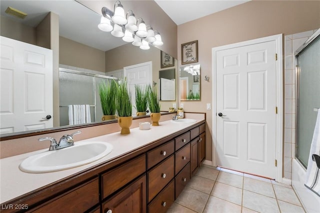 bathroom with tile patterned flooring, vanity, and bath / shower combo with glass door