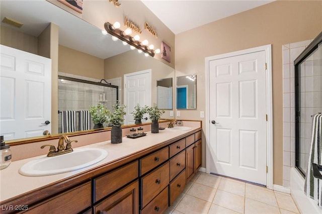 bathroom featuring tile patterned flooring, vanity, and enclosed tub / shower combo