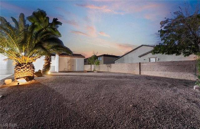 yard at dusk with a storage shed