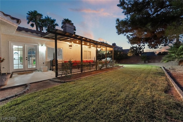 yard at dusk with french doors, an outdoor living space, a patio, and a pergola