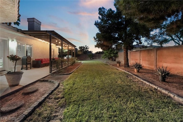 yard at dusk featuring an outdoor living space and a patio area